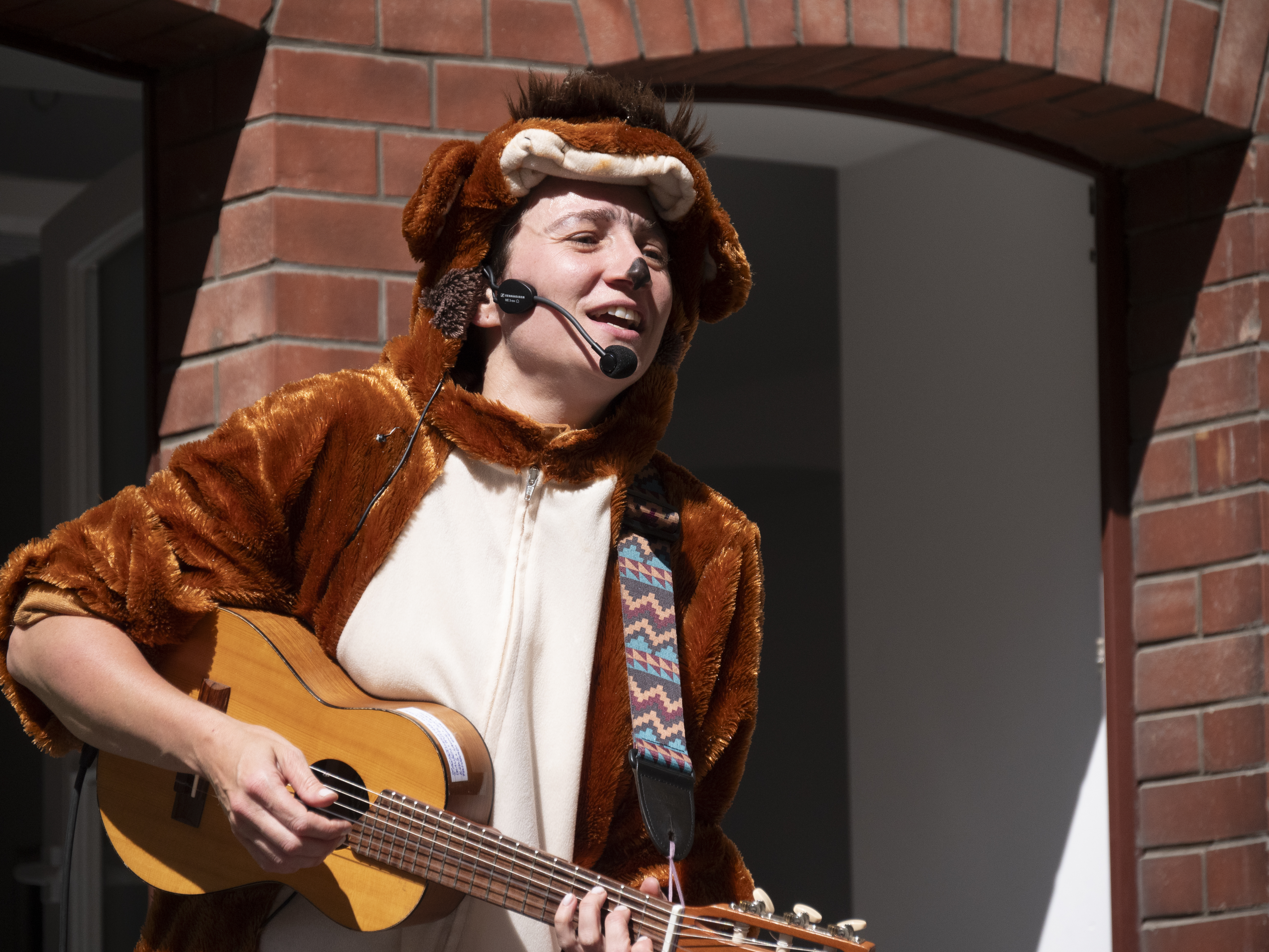 Kinderkonzert von Monkey und Ich eine Frau in einem braunen Affenkostüm spielt Gitarre und singt dazu